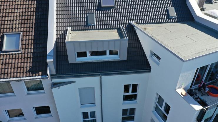Dachsanierung mit Gaubeneinbau Luftaufnahme eines Wohnhauses mit frisch gedecktem Dach und moderner Fenstergaube.