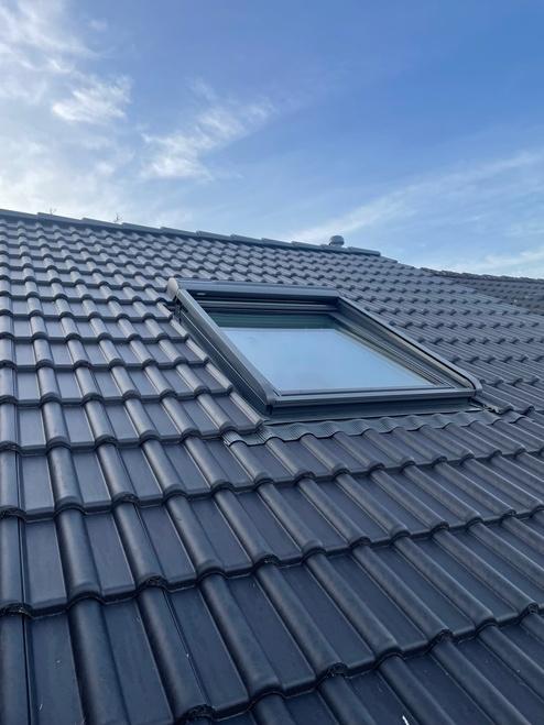 Eingebautes Dachfenster Ziegeldach Dunkles Ziegeldach mit neu eingebautem Dachfenster und sauber eingepasster Abdichtung.