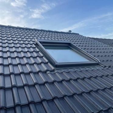 Eingebautes Dachfenster Ziegeldach Dunkles Ziegeldach mit neu eingebautem Dachfenster und sauber eingepasster Abdichtung.