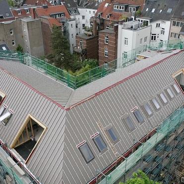 Dachausbau mit Dachfenstern Großes Gebäudedach mit Gerüst, Dachfenstern und laufenden Ausbauarbeiten.