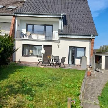 Wohnhaus mit Balkon und Garten Zweistöckiges Wohnhaus mit Balkon, Terrasse und gepflegtem grünen Vorgarten.